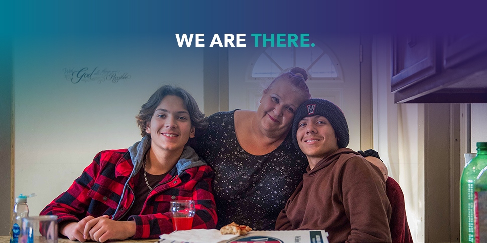 We Are There campaign graphic featuring a woman and her two sons. She has her arms around them and they're all smiling.