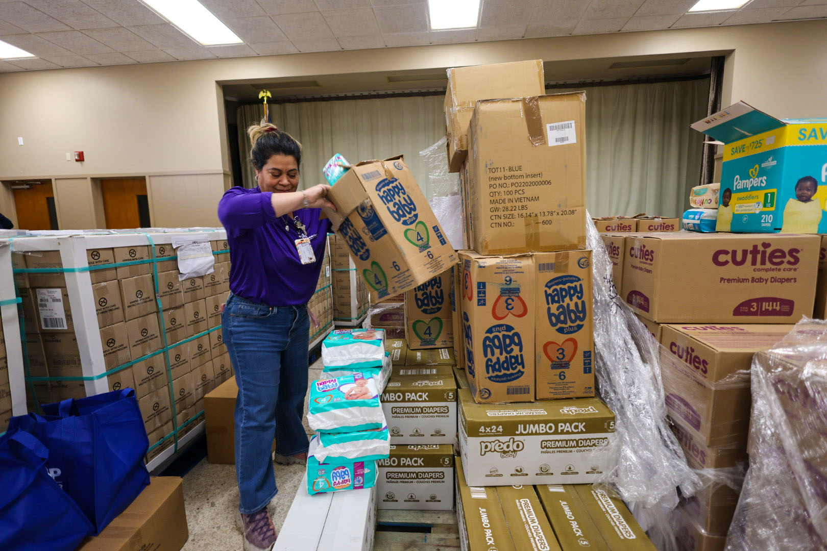 A Catholic Charities staff member organizes diapers for distribution at a Catholic Charities Diocese of St. Petersburg location after Hurricane Helene.