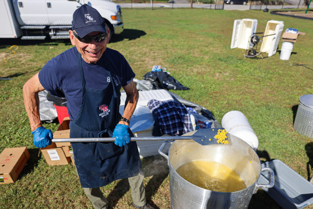 A volunteer at a Catholic Charities Diocese of Charlotte distribution site in Asheville, NC, prepares food after Hurricane Helene.