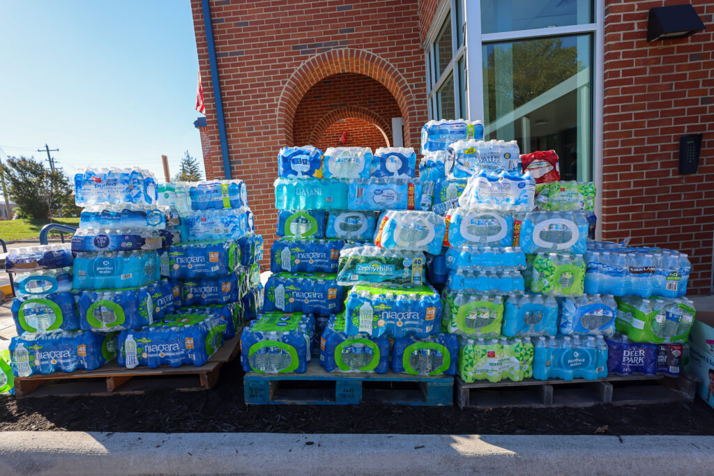 Water is stacked on pallets at a Catholic Charities Diocese of Charlotte distribution site in Asheville, NC, after Hurricane Helene.